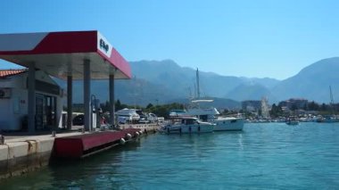 Bar, Montenegro 10 August 2025: Enjoy peaceful view of beautiful harbor. Witness boats gently bobbing in calm waters under clear blue sky, surrounded by majestic mountains. Water tourist excursion.