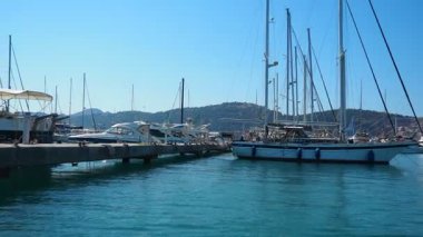 Karadağ 'ın Bar, 10 Ağustos 2025: Güzel limanın huzurlu manzarasının tadını çıkarın. Mavi gökyüzünün altında sakin sularda sallanan tekneler görkemli dağlarla çevrili. Su turisti gezisi.