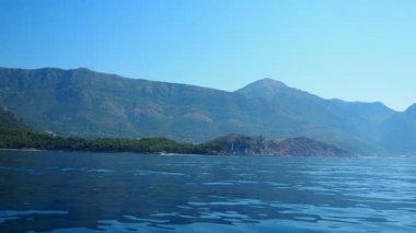 Karadağ 'ın engebeli kıyı şeridi boyunca nefes kesici tekne turu. Yelkenli mavisi Adriyatik Denizi, dramatik uçurumlar, büyüleyici kıyı ormanı. Sutomore, Devachen Sahili, Zagradje. Kızıl uçurum. Yaz turizmi.