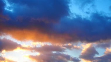 Gün batımında gökyüzünün dönüşümünü izle, renklerin bir karışımını sergiliyor. Bulutlar yüzer ve şehrin üzerinde güzel bir doğa manzarası yaratır. Dramatik bir gökyüzü. Alacakaranlık renkli akşam silüeti.