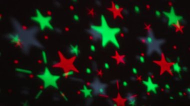 Parlak Beş Noktalı Yıldızlar Parıldıyor, Renkli Aydınlatma Siyah Arkaplanda Dans Ediyor. Işığın büyüleyici görüntüsü ve yansıması, onlara bakan herkesi büyülüyor. Kırmızı ve Yeşil Renk.