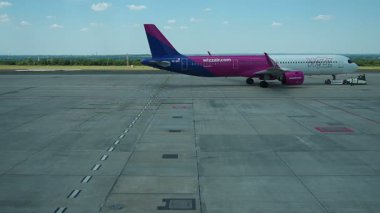 Budapeşte, Macaristan 01 Ağustos 2025: Havalimanı 'na indikten sonra Wizz Air yolcu uçağının manevrası sorunsuz bir şekilde durdu. Havacılığın hassasiyetini tecrübe edin ve sinek manzarasının tadını çıkarın. Macar Havayolları