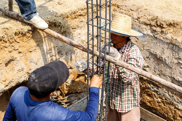 Pracovník ohýbání ocelové tyče pro stavební práce — Stock fotografie