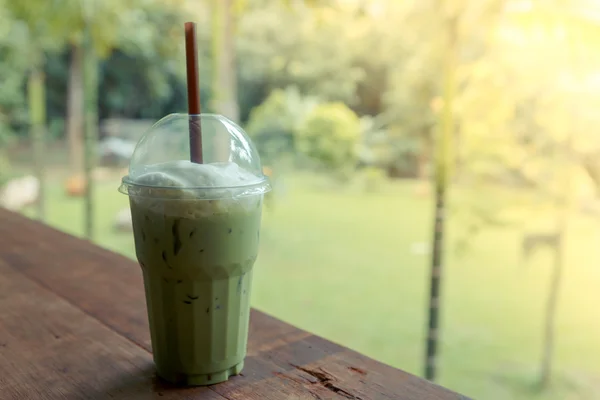 Té verde helado con leche en la mesa en la cafetería —  Fotos de Stock