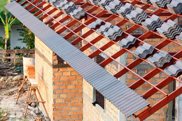 Roof under construction with stacks of roof tiles for home build — Stock Photo, Image