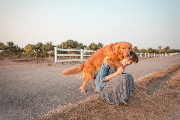 Beautiful woman with a cute golden retriever dog — Stock Photo, Image