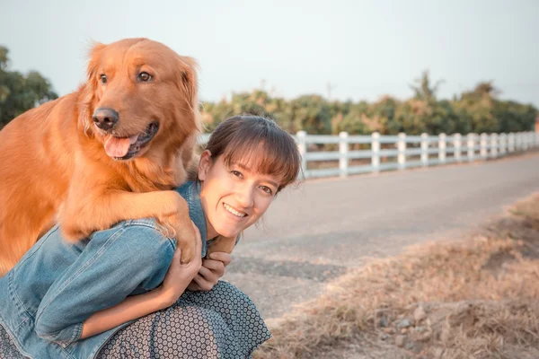 Szép nő, egy aranyos golden retriever kutya — Stock Fotó