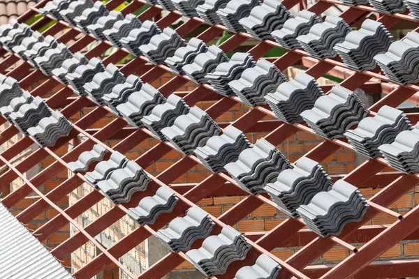 Roof under construction with stacks of roof tiles for home build — Stock Photo, Image