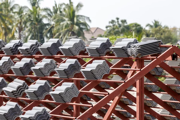 Toit en construction avec des piles de tuiles de toit pour la construction de la maison — Photo