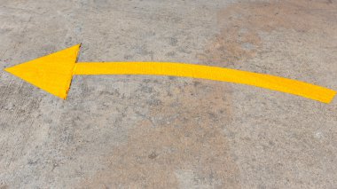 Beton yol üzerindeki sarı trafik oku 