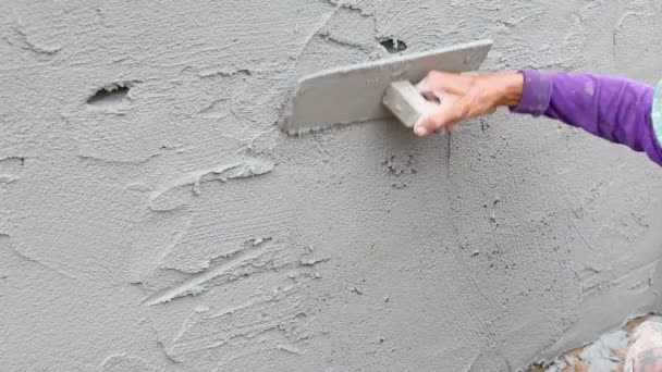 Arbeiter putzt Beton an Hauswand — Stockvideo