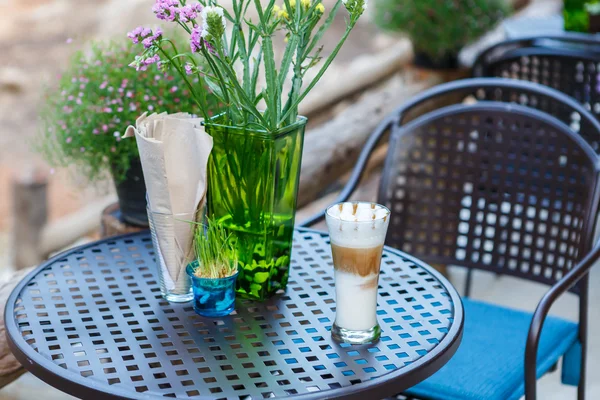 Vaso de café capuchino caramelo en la mesa en la cafetería —  Fotos de Stock