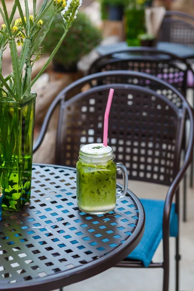 Té verde helado con leche en la mesa en la cafetería —  Fotos de Stock