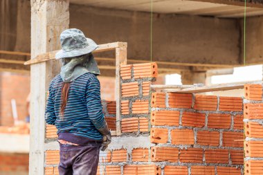 Kadın mason tuğla duvar yapar