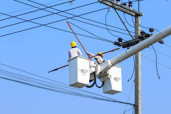 Eletricista trabalhando no poste elétrico — Fotografia de Stock