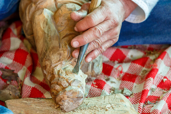 Hand of carver carving wood