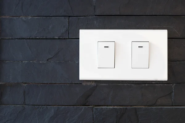 Interruttore luce su muro di pietra nera — Foto Stock