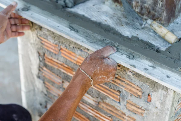 Штукатурщик бетона на стене домостроения — стоковое фото