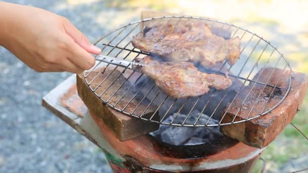 Mão vira a carne na grelha — Vídeo de Stock