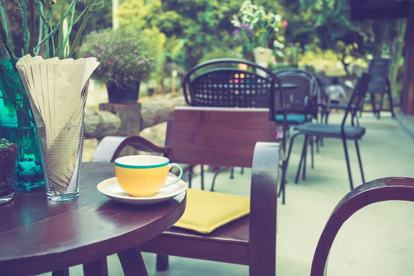 Чашка кави на столі в кафе з вінтажним кольоровим тоном — стокове фото