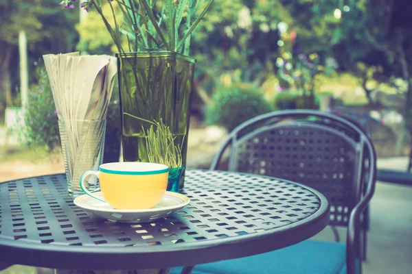 Taza de café en la mesa en la cafetería con tono de color vintage —  Fotos de Stock