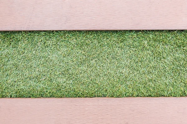 Artificial grass with wooden texture backgroud — Stock Photo, Image