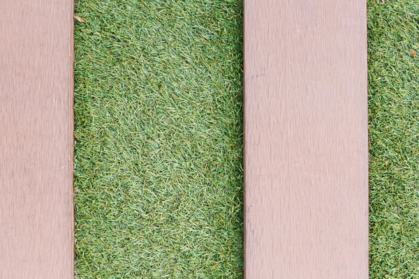 Artificial grass with wooden texture backgroud — Stock Photo, Image