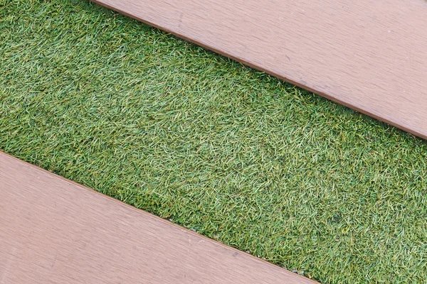 Artificial grass with wooden texture backgroud — Stock Photo, Image