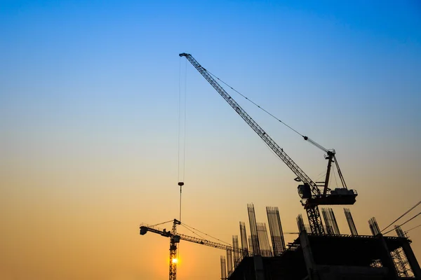 Construcción con grúas sobre fondo de silueta — Foto de Stock