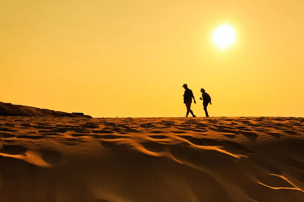Two people walking on sand desert — Stock Photo, Image