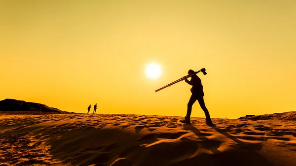 Um homem caminhando no deserto de areia — Fotografia de Stock