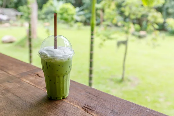 Té verde helado con leche en la mesa en la cafetería —  Fotos de Stock