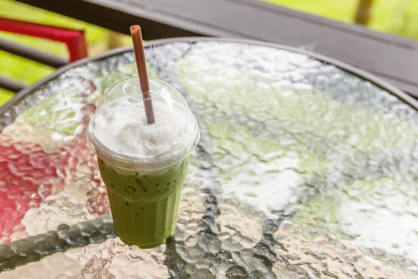 Té verde helado con leche en la mesa en la cafetería —  Fotos de Stock