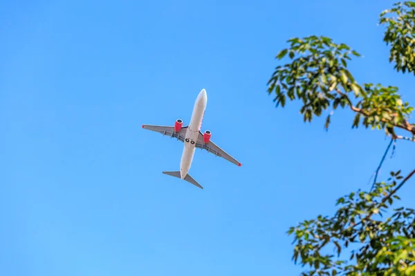 Avião prepara pouso no céu azul — Fotografia de Stock