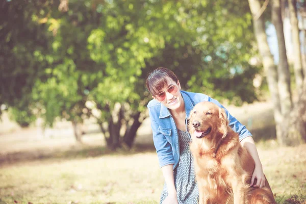 Hermosa mujer con un lindo perro recuperador de oro — Foto de Stock
