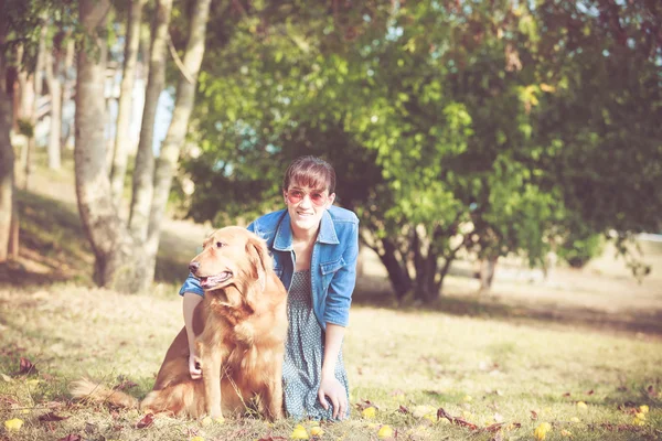 Szép nő, egy aranyos golden retriver kutyák — Stock Fotó