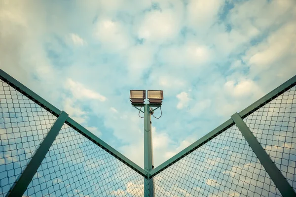 Luci dello stadio sotto il cielo blu con tonalità pastello — Foto Stock