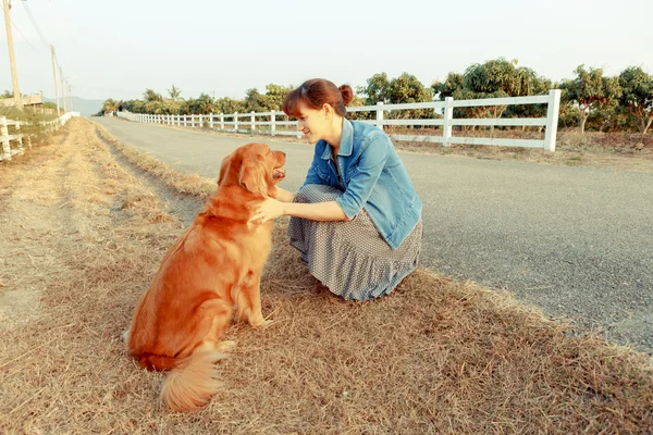 Szép nő, egy aranyos golden retriever kutya — Stock Fotó