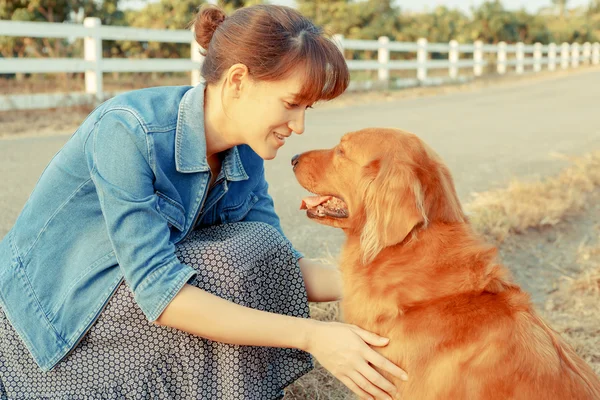 Hermosa mujer con un lindo perro golden retriever — Foto de Stock