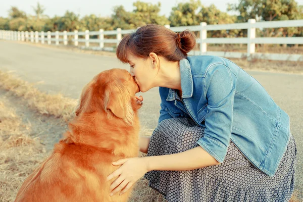 Mulher bonita com um cão bonito golden retriever — Fotografia de Stock