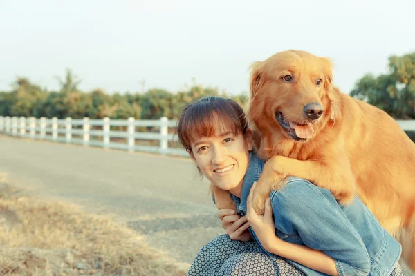Hermosa mujer con un lindo perro golden retriever — Foto de Stock