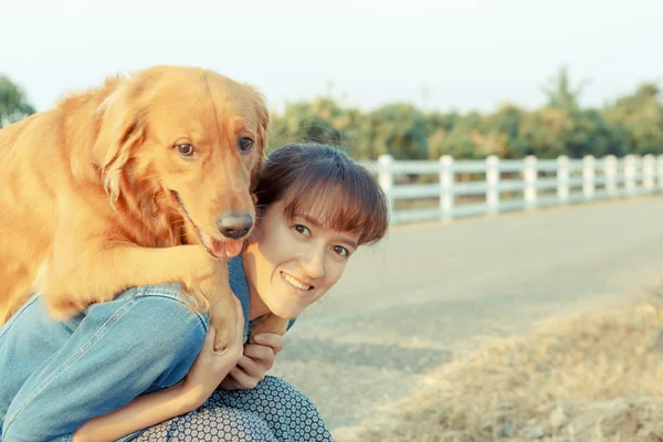 Belle femme avec un chien golden retriever mignon — Photo