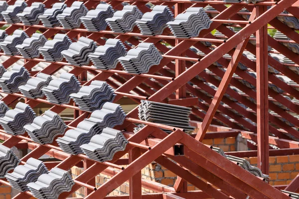 Telhado em construção com pilhas de telhas para construção em casa — Fotografia de Stock