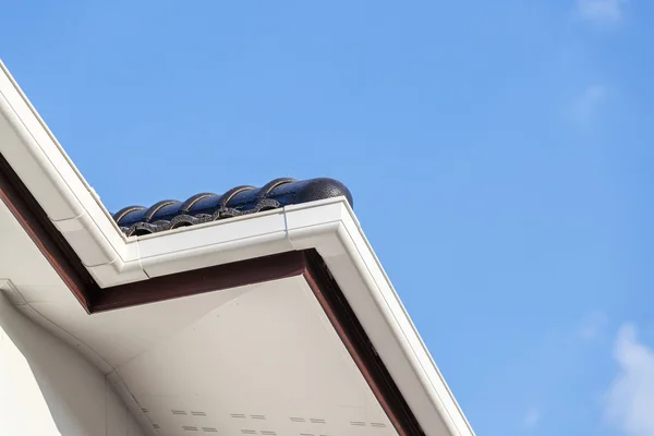 Weiße Dachrinne auf dem Dach des Hauses lizenzfreie Stockfotos