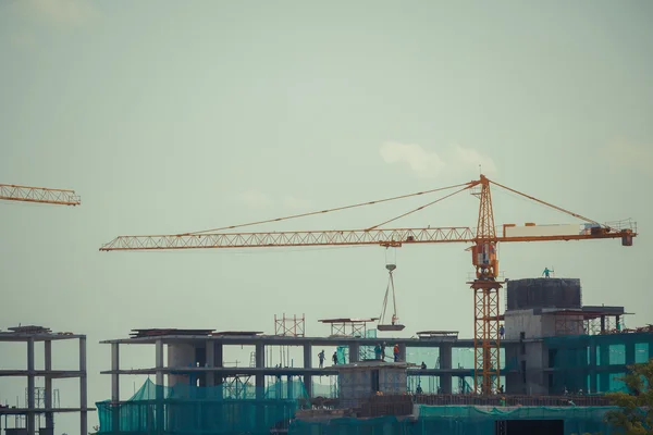 Construcción de grúas y obras bajo el cielo azul — Foto de Stock