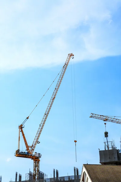 Строительный кран и строительная площадка под голубым небом — стоковое фото