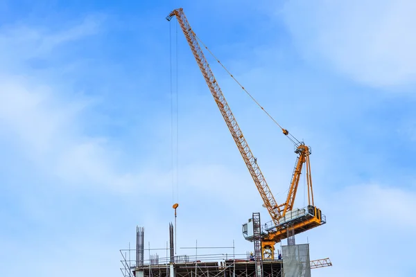 Building crane and construction site under blue sky — Stock Photo, Image