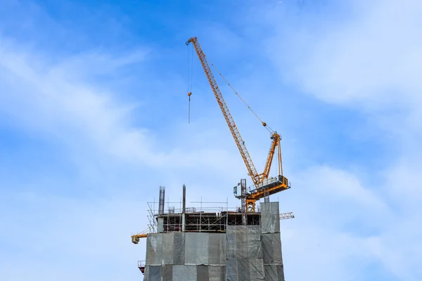 Building crane and construction site under blue sky — Stock Photo, Image