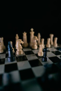 Satranç tahtasındaki satranç taşları karanlık bir stile sahip. Seçici odak