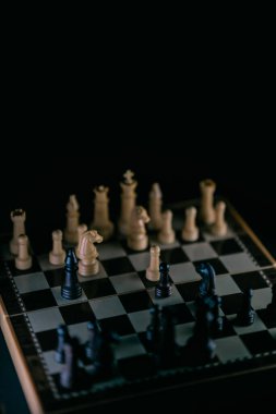 Satranç tahtasındaki satranç taşları karanlık bir stile sahip. Seçici odak